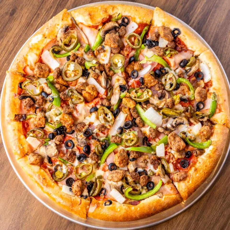A whole pizza with sausage, black olives, green peppers, onions, mushrooms, and jalapeños.
